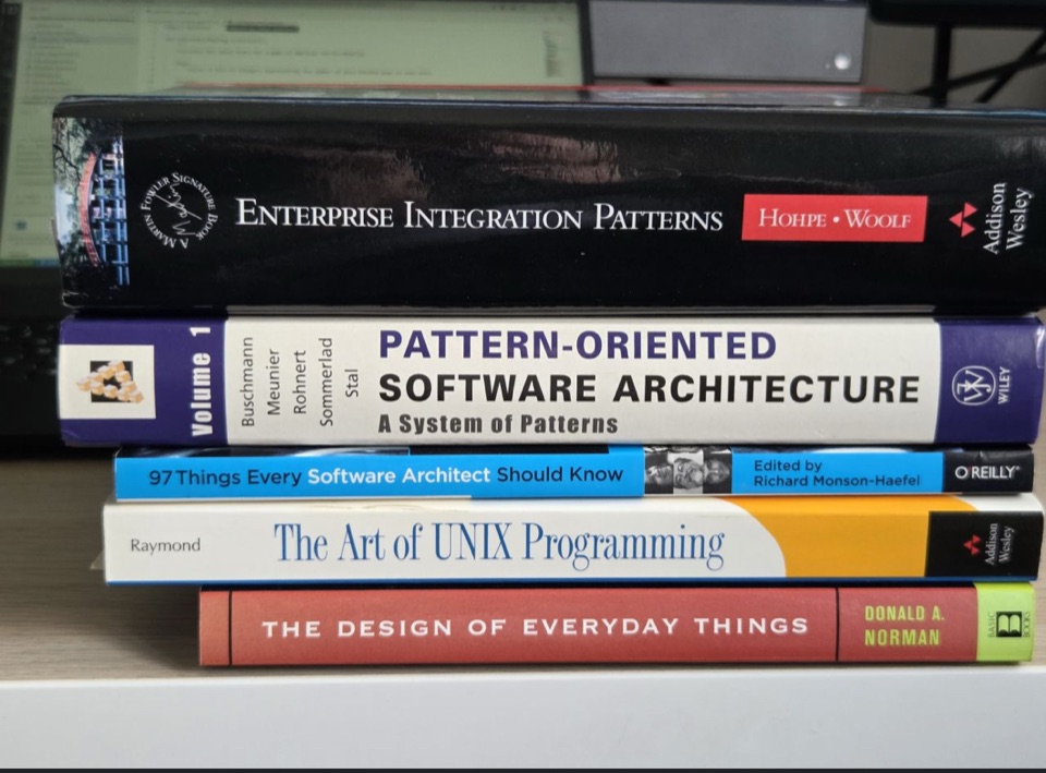 A stack of software architecture books, from Enterprise Integration Patterns to The Design of Everyday Things
